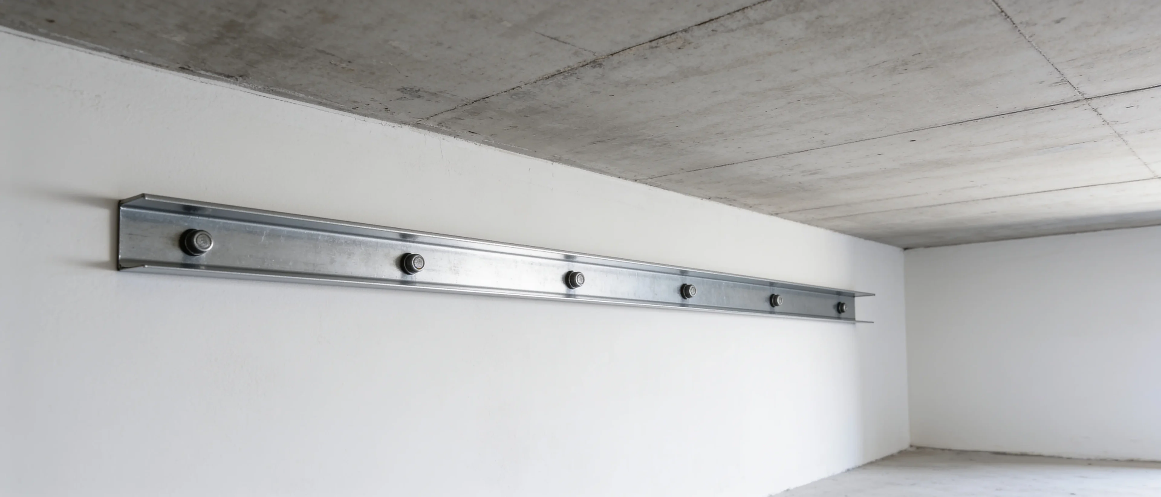 UD-Randprofil an der Wand unter der Rohdecke, durch den Steg direkt an die Wand gedübelt